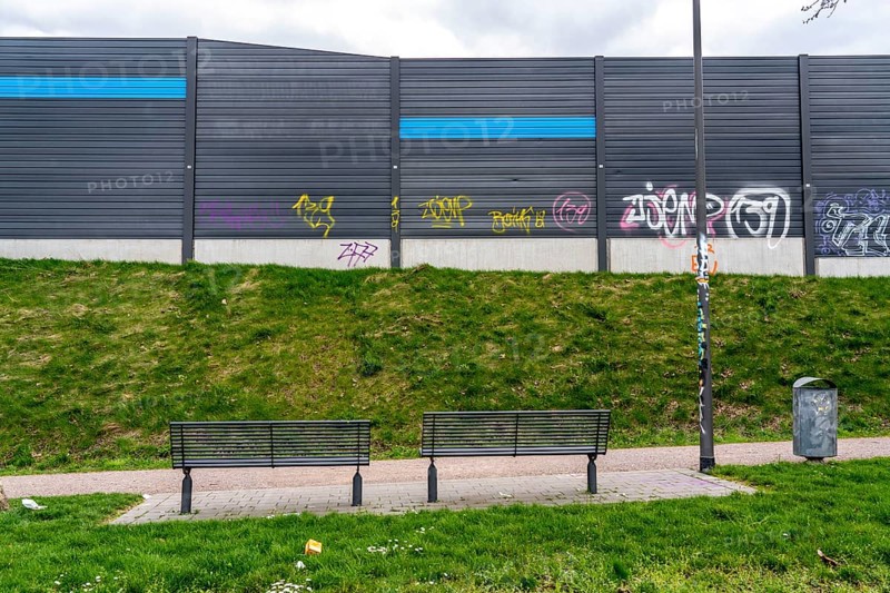 Green space, in Duisburg-Beck, park bench with view of the noise barrier of the A42 motorway, Emscherschnellweg, North Rhine-Westphalia, Germany, Europe