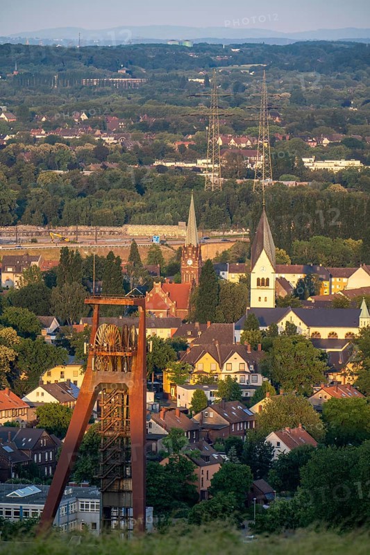 Residential estate in the countryside, terraced houses, multi-family houses, parts of former mining estate in Recklinghausen-Hochlarmark, headframe of former Recklinghausen colliery, Shaft IV, St Michael's Church, right and Reformation Church, left, North Rhine-Westphalia, Germany, Europe