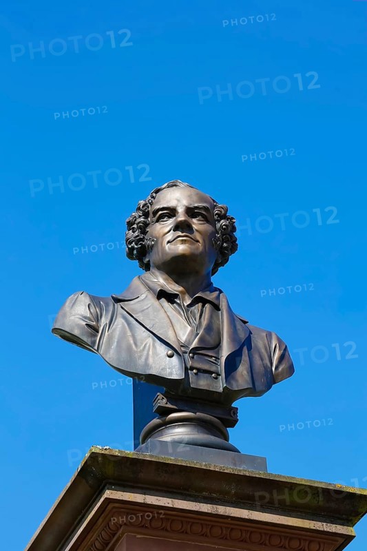 Monument in honour of Conradin Kreutzer, musician, conductor and composer, bust by Hans Baur, sculptor, sculpture, portrait, portrait, head, face, detail, pedestal, writing, letters, art in public space, statue, blue sky, cloudless, Meßkirch, district of Sigmaringen, Baden-Württemberg. Germany