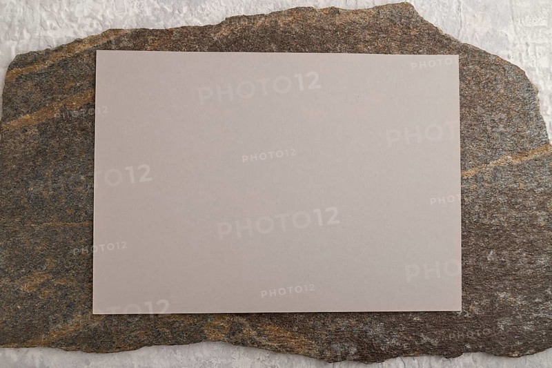 Beige paper business card, mockup with natural stone on gray concrete background. Blank, flat lay, top view, still life, copy space