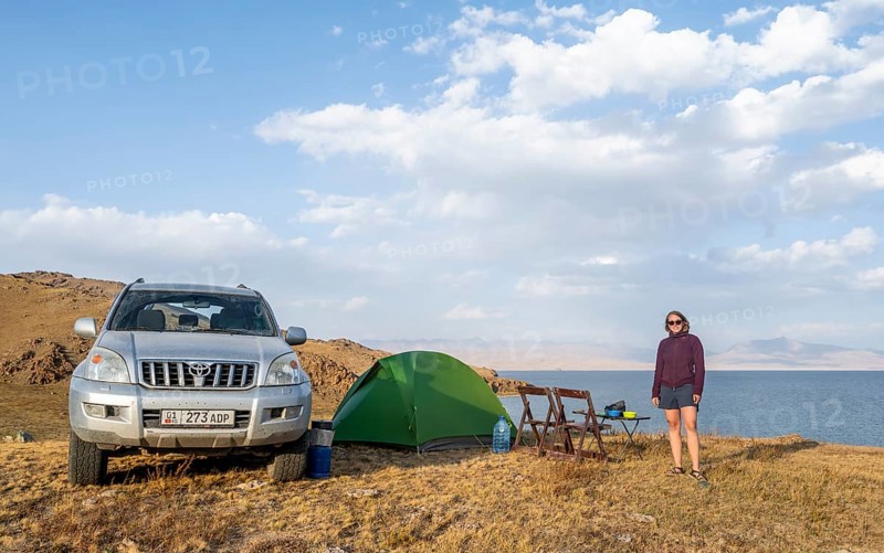 Hiker in front of a tent, camping in the highlands, Song Kul mountain lake, Naryn region, Kyrgyzstan, Asia