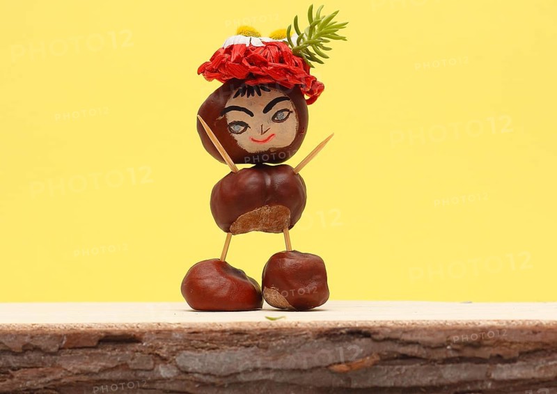 Funny chestnut figure with hat standing in front of a yellow wall, North Rhine-Westphalia, Germany, Europe