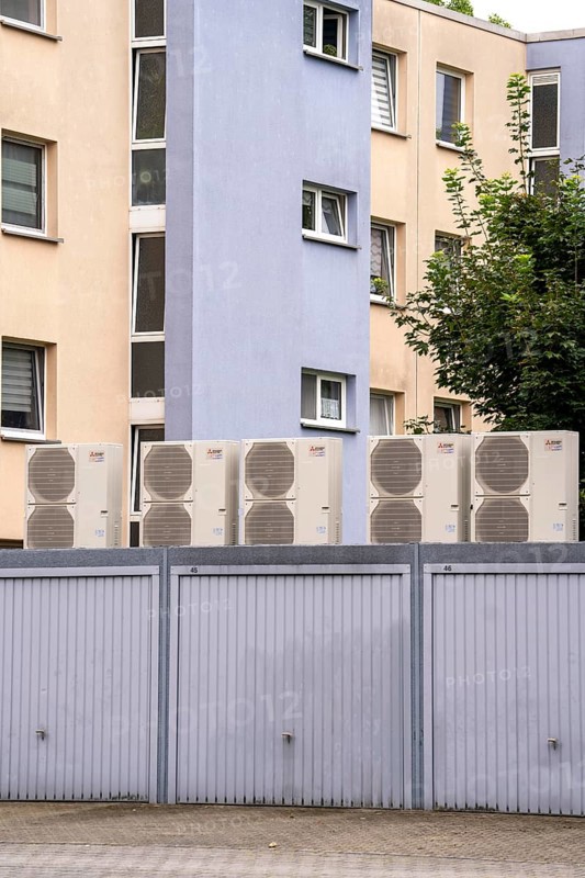 Heat pumps in a residential area, multi-family houses are supplied with heating, cooling and domestic hot water via these devices, installed on garage roofs, modernisation of the flats, Duisburg, North Rhine-Westphalia, Germany, Europe