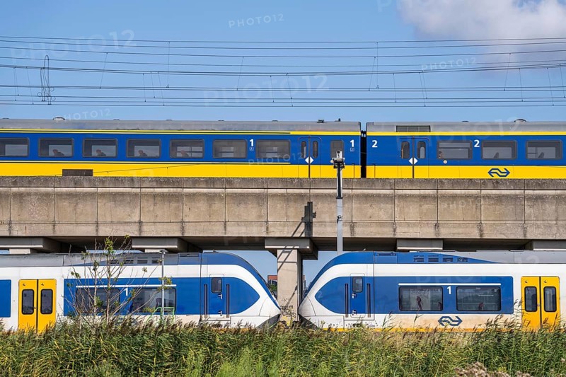 Trains of the Dutch railway, NS, Nederlandse Spoorwegen N.V., on a double-decker track, below local train Sprinter Light Train, above Intercity Direct train, near Hoofddorp, municipality of Haarlemmermeer, near Amsterdam