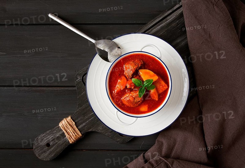 Stew with potatoes, in tomato sauce, with spices and herbs, close-up, no people, on a black background