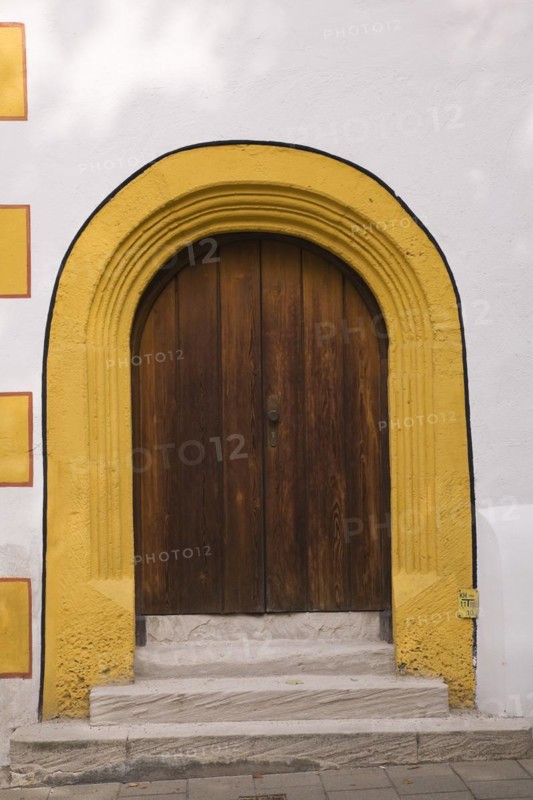 Old wooden entrance door with doorstep and yellow contour on facade of Stadtsall hotel building in medieval town of Nordlingen, Bavaria, Germany, Europe