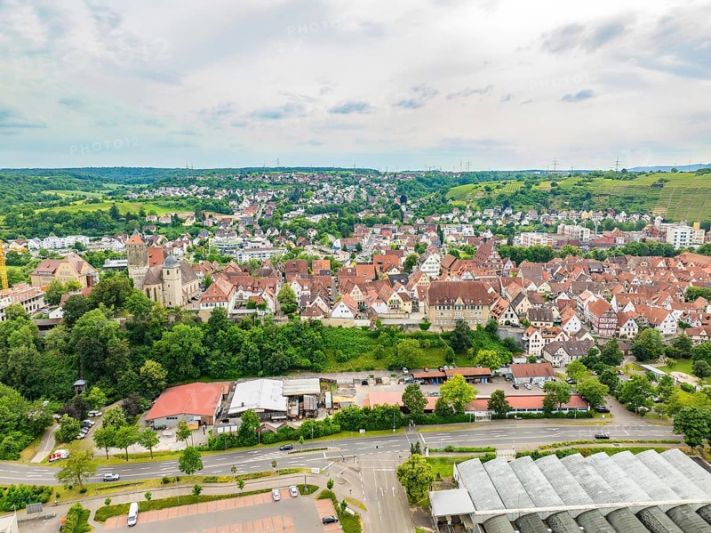 Overview of a town with red tiled roofs, embedded in hilly, green landscapes, crossed by various roads, Besigheim, Germany, Europe