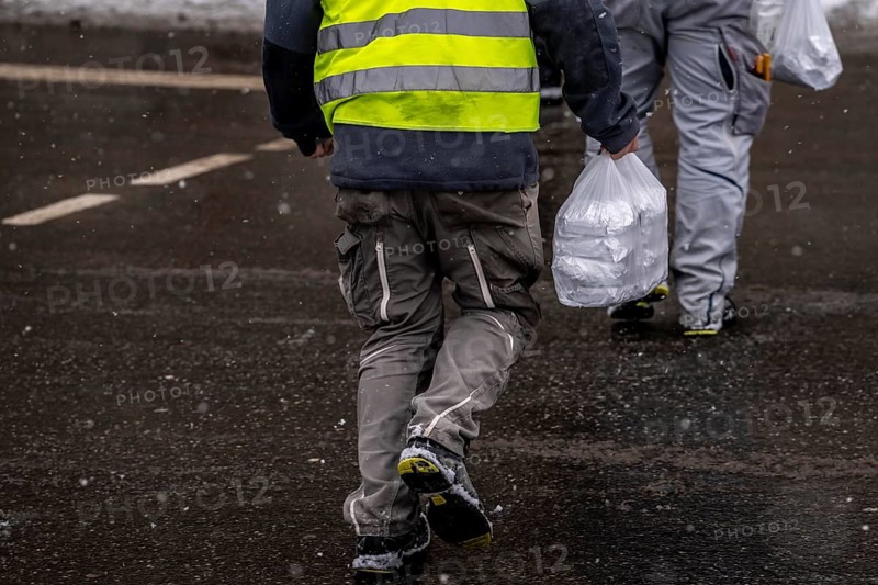 Winter in Frankfurt, worker of a large construction site has bought lunch for himself and colleagues at a snack bar, snowy, Hesse, Germany, Europe
