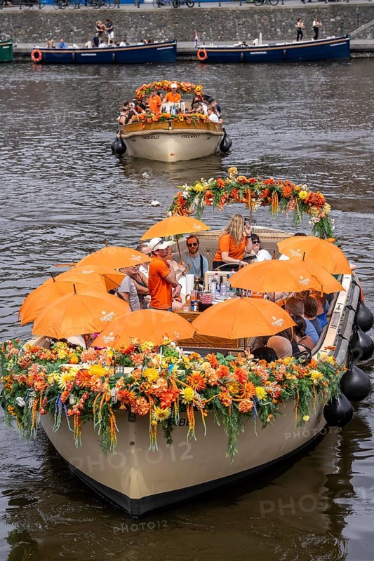 Canal cruise, with flagship organiser, canal boats decorated with flowers, passengers with umbrellas against the summer sun, heat, pier at Centraal Station, excursion boat, Amsterdam Netherlands