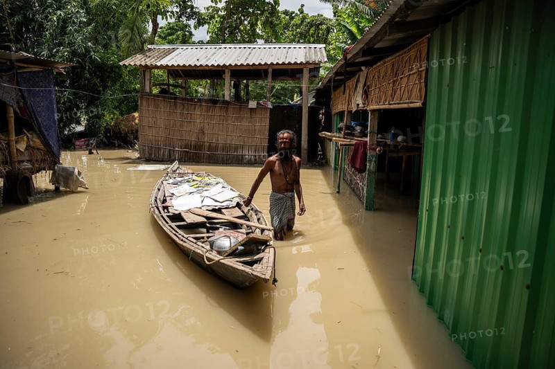 Morigaon, India. 4 July 2024. A person dry his childrens books in a boat next to his flooded house in a flood affected village in Morigaon district in India's northeastern state of Assam on July 4, 2024. Torrential rains and surging rivers across northeast India have killed at least nine people, with more than 1.5 million people affected
