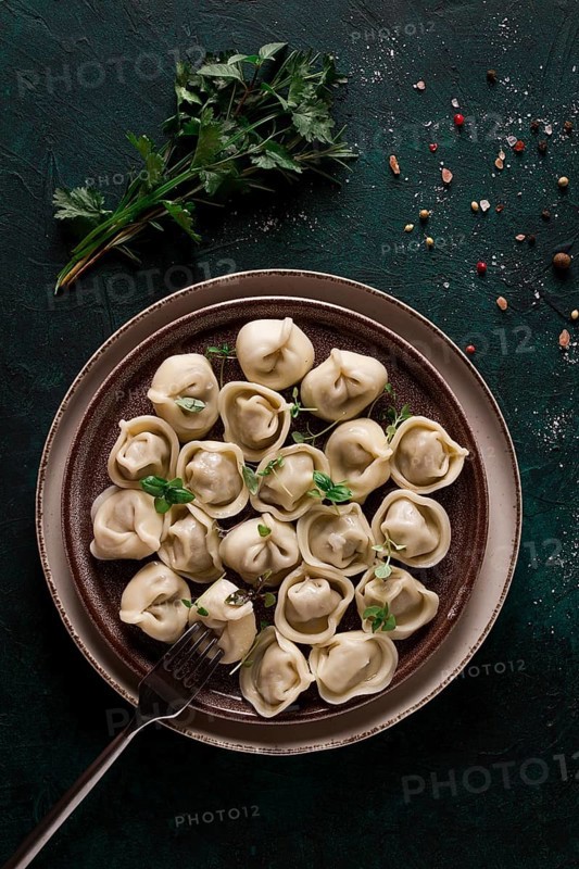 Dumplings, on a dark background, with spices and herbs, vertical, no people