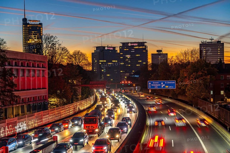 Evening traffic, partly with traffic jams, slow-moving traffic on the A40 motorway, skyline of Essen, RWE tower on the left, Evonik Group headquarters in the middle, former Postbank building on the right, Essen, North Rhine-Westphalia, Germany, Europe
