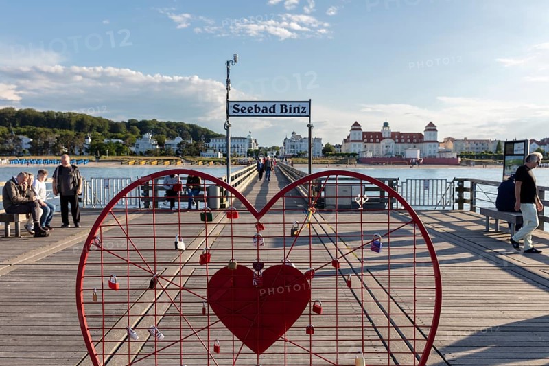Red heart with castles on a pier with a view of the Seebad Binz building, Rügen, Binz