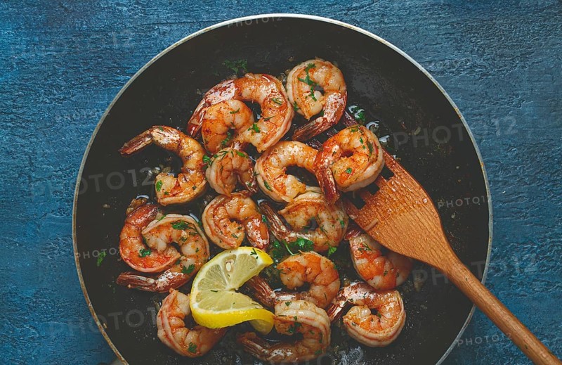 Fried tiger prawns, jumbo, in garlic sauce, in butter, with herbs, in a frying pan, homemade, no people