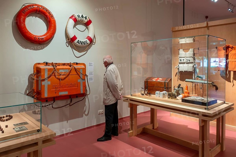 Elderly visitor looking at maritime exhibition at NAVIGO Visserijmuseum, fishery museum at Oostduinkerke, Koksijde, West Flanders, Belgium. Model released