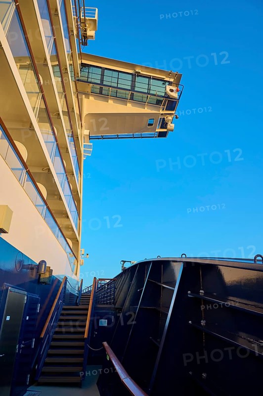 Modern cruise ship substructure with railings, windows and bridge under a bright blue sky with a view of the bridge, cruise ship Mein Schiff 6, North Sea, Denmark, Europe