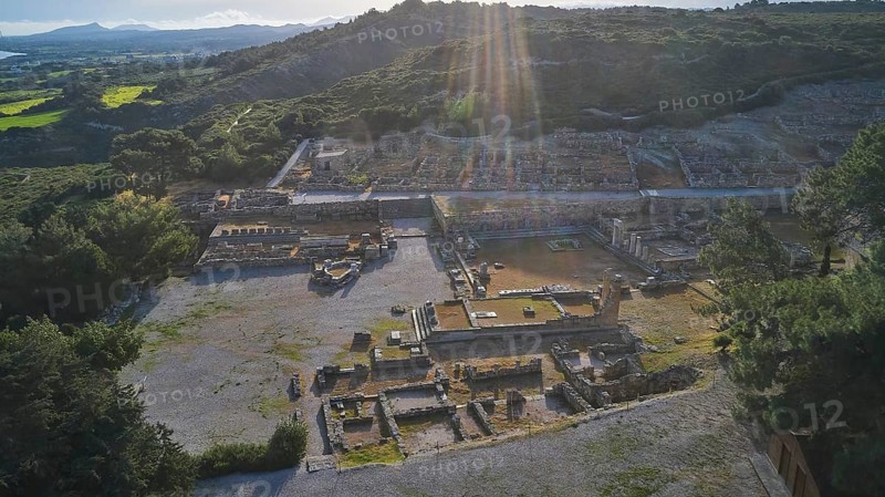 Drone shot, first morning light, backlight, sun rays, Ancient ruins of an archaeological site illuminated by sun rays, surrounded by nature and mountains, Kamiros, Archaeological site, Ancient city, Foundation of Doric Greeks, Rhodes, Dodecanese, Greek Islands, Greece, Europe
