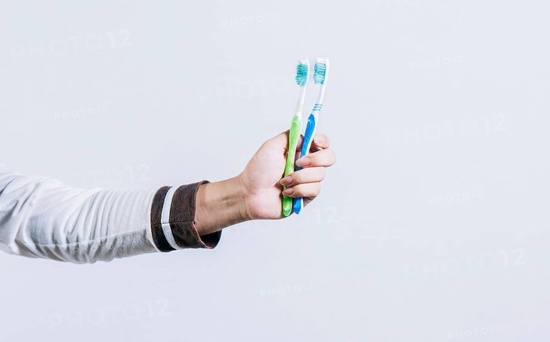 Toothbrush change concept. Hand holding two toothbrushes isolated. Oral health concept