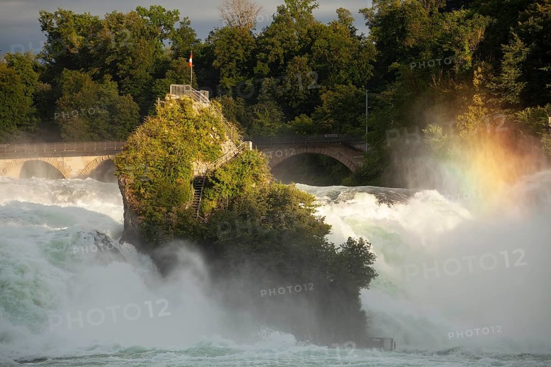 The Rhine Falls at Schaffhausen in Switzerland with rainbow colours and the Middle Rock. An extreme amount of water in 2024