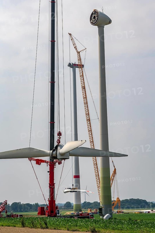 Dismantling of a wind power plant in a wind farm near Issum, 9 older wind turbines from the manufacturer Enercon (model series E-58), front, blades being dismantled, were in operation for over two decades, will be replaced by a total of four Enercon E-160 turbines, rear, assembly of the first blade, with a total output of 22 megawatts, Lower Rhine, North Rhine-Westphalia, Germany, Europe