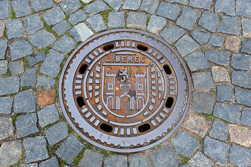 Manhole cover with Liberec city coat of arms, surrounded by cobblestones, manhole cover, Liberec, Reichenberg, Bohemia, Czech Republic, Europe