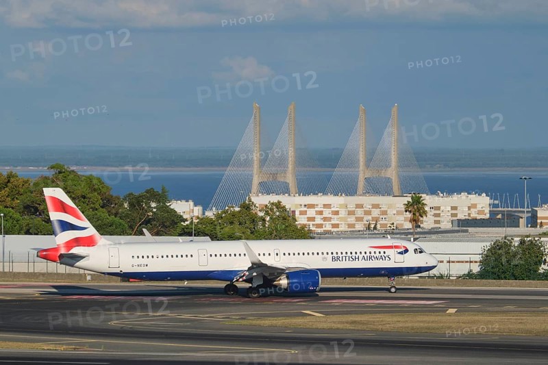 Lisbon, Portugal - September 2, 2023: British Airways Airbus A321-251NX passenger plane taxi on runway in Humberto Delgado Airport in Lisbon with Vasco da Gamma bridge in background