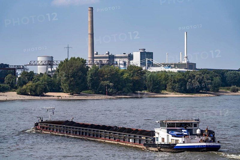 Shipping traffic on the Rhine near Düsseldorf, freighter Christa, loaded with coal for power stations, in the background the Lausward CHP plant, a combined-cycle gas and steam turbine power station, North Rhine-Westphalia, Germany, Europe
