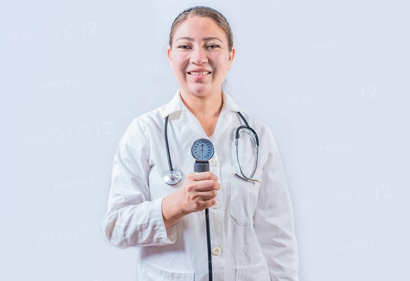 Young female doctor holding tensiometer on isolated background. Smiling female doctor showing blood pressure monitor isolated