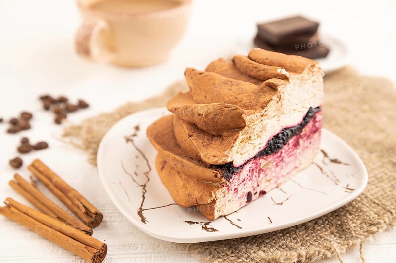Zephyr or marshmallow cake with cup of coffee on white wooden background and linen textile. side view, close up, selective focus