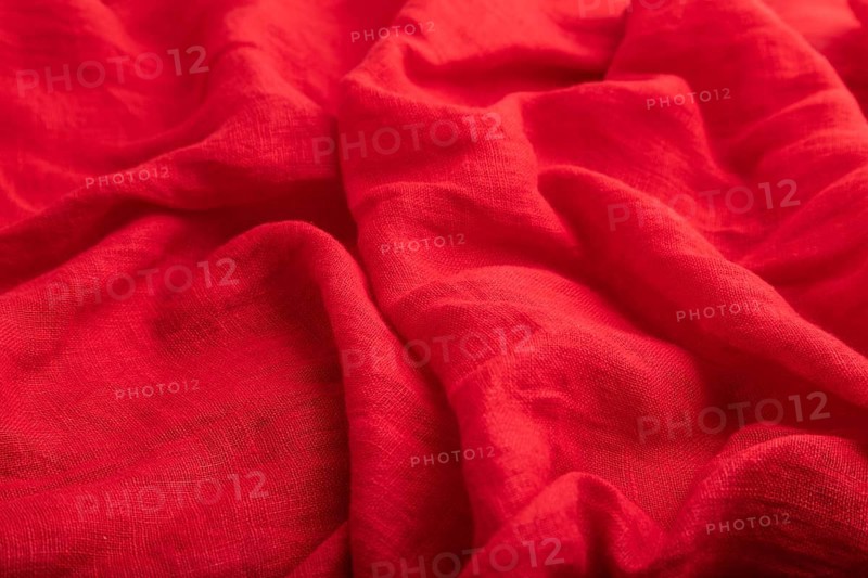 Fragment of red linen tissue. Side view, natural textile background and texture. wave concept, abstract
