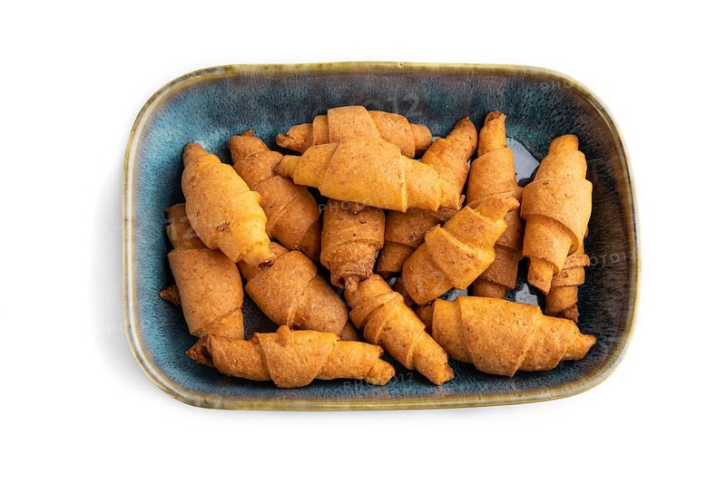 Homemade bagel roll on blue ceramic plate isolated on white background. top view, flat lay, close up
