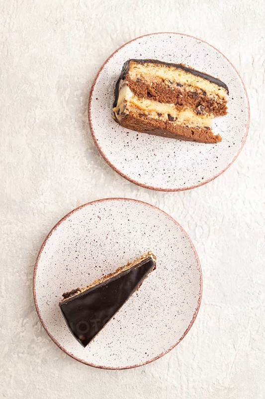 Chocolate biscuit cake with caramel cream and walnuts, on gray concrete background. top view, flat lay, close up
