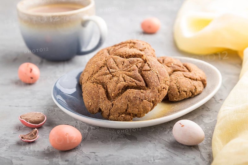 Homemade oatmeal cookies with a cup of cocoa and a yellow textile on a gray concrete background. side view, close up, selective focus
