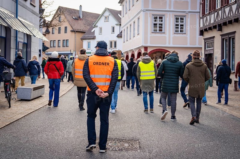 Rear view of an organiser walking through a city street, Gegen Rechts Demo, Nagold, Black Forest, Germany, Europe