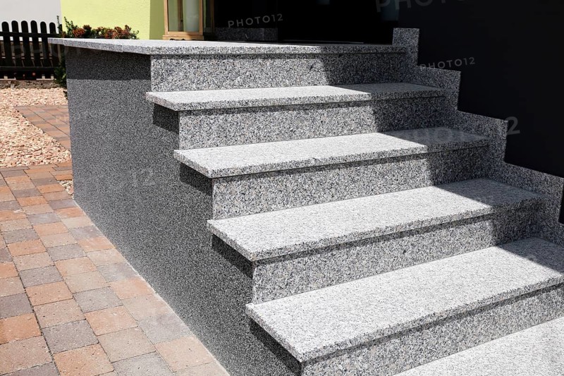 Block stepped staircase with plinth made of coloured stone plaster as an entrance staircase to a residential building