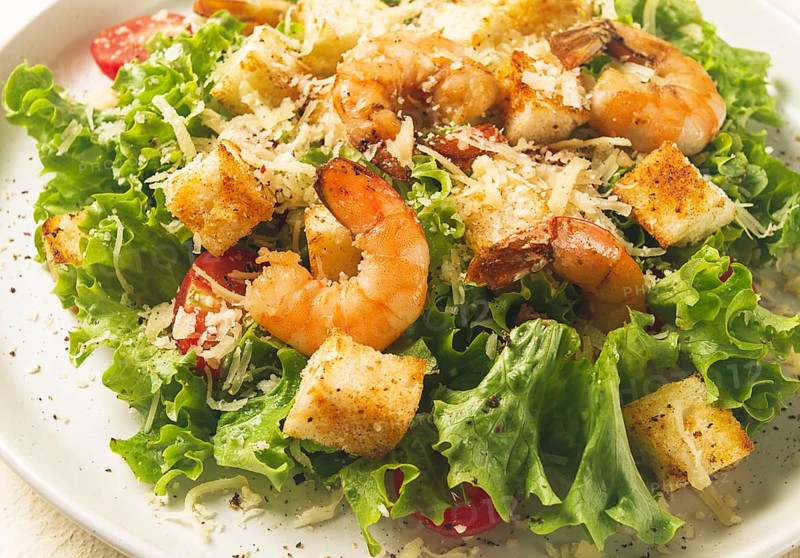 Caesar salad, with shrimp, on a white background, homemade, no people