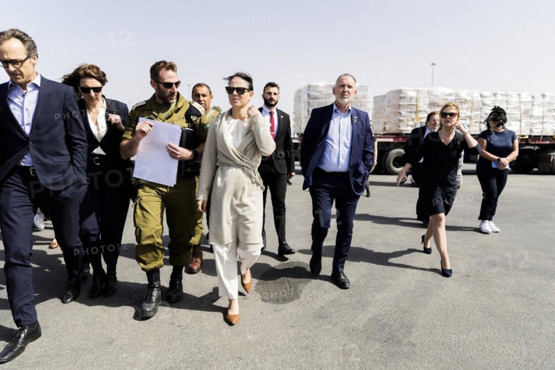 Annalena Bärbock (Alliance 90/The Greens, M), Foreign Minister, is shown trucks carrying humanitarian aid by a representative of the COGAT unit of the Israeli Ministry of Defence (3rd from left) during a visit to the Kerem Shalom border crossing to the Gaza Strip on the Israeli side. Relief supplies are transported by lorry from the border crossing in the tri-border region of Egypt, Israel and the Gaza Strip to the Gaza Strip. Foreign Minister Bärbock is visiting Israel for the sixth time since the Hamas attack on Israel on 7 October to discuss the situation in Gaza and Israel once again