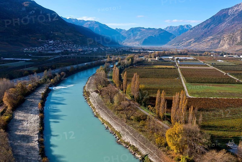 The wide river valley of the canalised Rhone, view downstream towards Martigny, with orchards on the right bank, Riddes, Valais, Switzerland, Europe