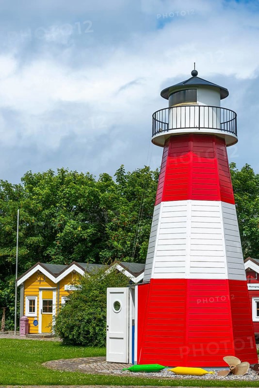 Colourful lobster shacks and lighthouse in the outdoor area of the museum with different themed areas, benches, paved path, offshore island of Heligoland, North Sea, Pinneberg district, Schleswig-Holstein, Germany, Europe