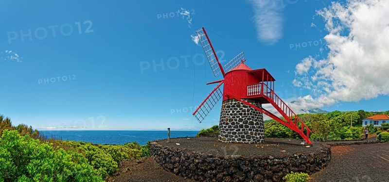 Red painted windmill on black volcanic stone Moinho de São João under a wide sky, São João, Pico Island, Azores, Portugal, Europe