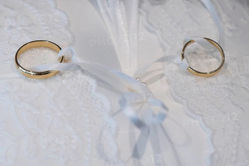 Wedding rings on an ornate white cushion