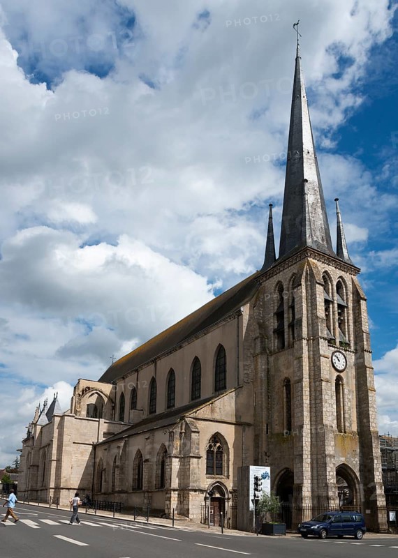 Alte Kirche mit hohem Turm unter einem teilweise bewölkten Himmel an einer Straße, Kirche, Église Saint-Jean-Baptiste, Nemours, Département Seine-et-Marne, Region Île-de-France, Ile-de-France, Frankreich