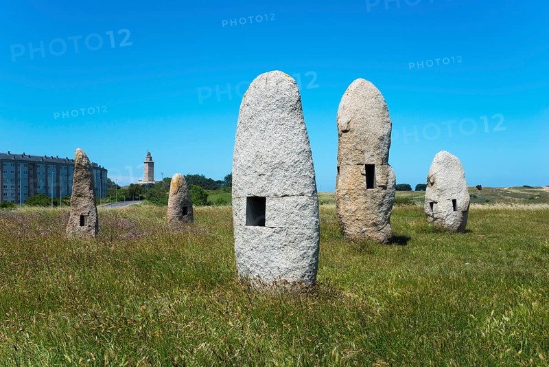 Stone formations in a meadow with a building in the background, under a clear blue sky, Menhires por la Paz, menhirs symbolising peace, Campo de la Rata, A Coruña, A Coruna, La Coruña, La Coruna, Galicia, Spain, Europe