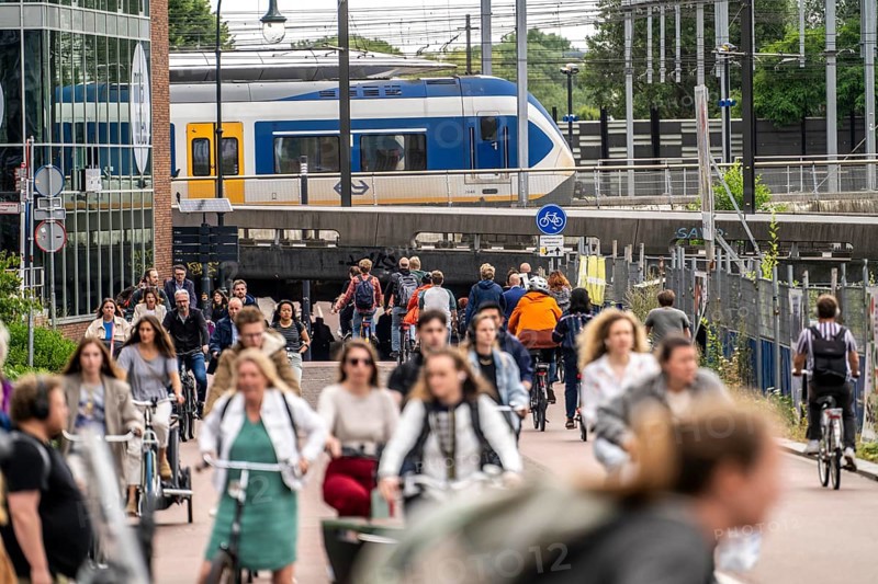 Central cycle path on Smakkelaarskade, at Utrecht Centraall station, in the centre of Utrecht, lanes for pedestrians, cyclists and cars are separated, waiting at traffic lights, heavy traffic, Netherlands