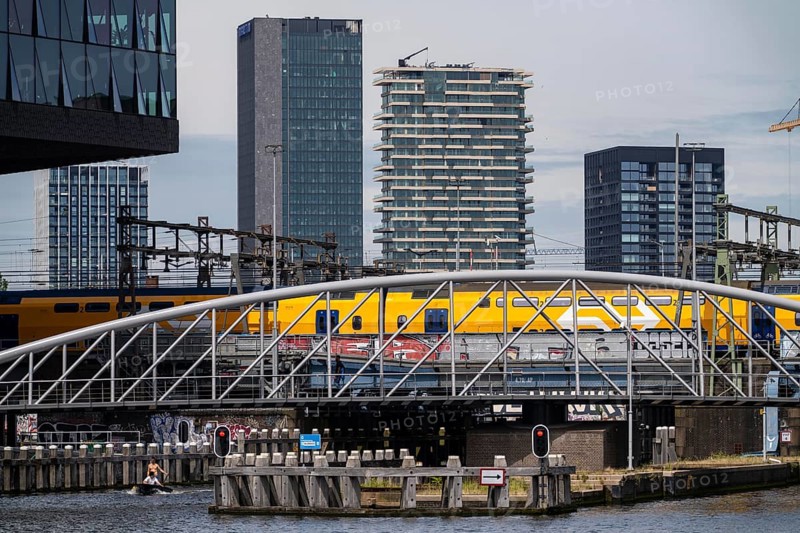 Railway bridge, line directly at Amsterdam Centraal station, crosses the canal from the river Ij to the Oosterdok harbour basin, intercity train, high-rise buildings in the Overhoeks district, Amsterdam, Netherlands