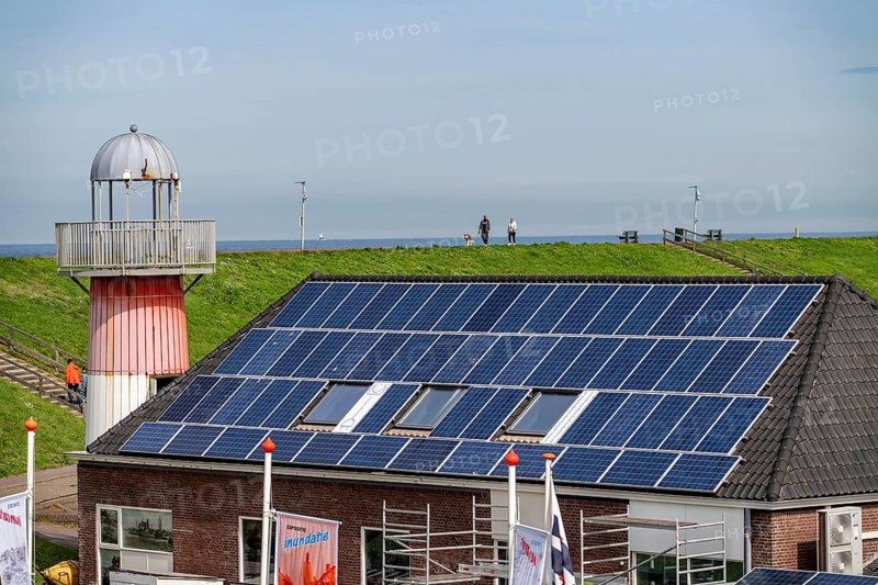 Solar modules on roofs, on the roof of a building on the dyke, North Sea coast, in Zeeland, Westkapelle, Netherlands