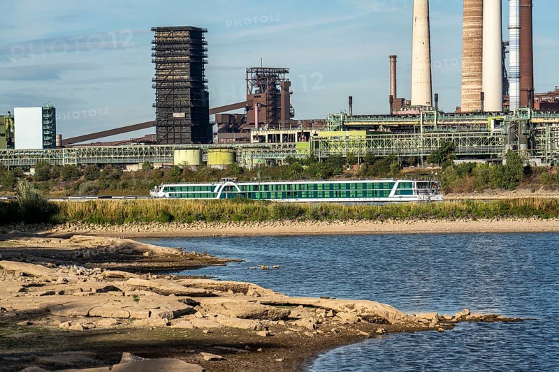 Low water level on the Rhine, banks dry up, sandbanks in the river, shipping can only navigate with reduced cargo and speed, Thyssenkrupp Steel, steelworks, Schwelgern coking plant, Duisburg-Bruckhausen, North Rhine-Westphalia, Germany River cruise ship