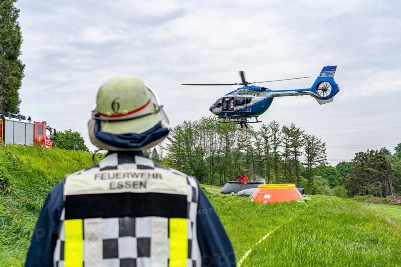 Forest fire fighting exercise of the Essen fire brigade, the water supply was rehearsed over longer distances to the scene of the operation, water basins were set up there from which a fire-fighting helicopter can take water, Airbus H145 of the North Rhine-Westphalia police aviation squadron with Bambi Bucket extinguishing water tank, North Rhine-Westphalia, Germany, Europe