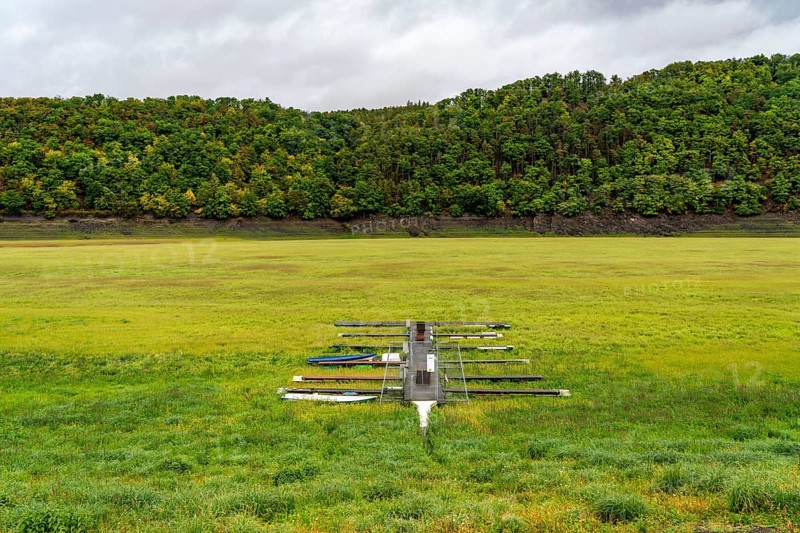 The Edersee, near Waldeck, the third largest reservoir in Germany, currently has only just under 13% of its normal level, the lake was last full in May 2022, dried out due to lack of rain, jetty, stranded fishing boat, rowing boat, the lake shore and the lake bottom is overgrown with fresh grass, Hesse, Germany, Europe