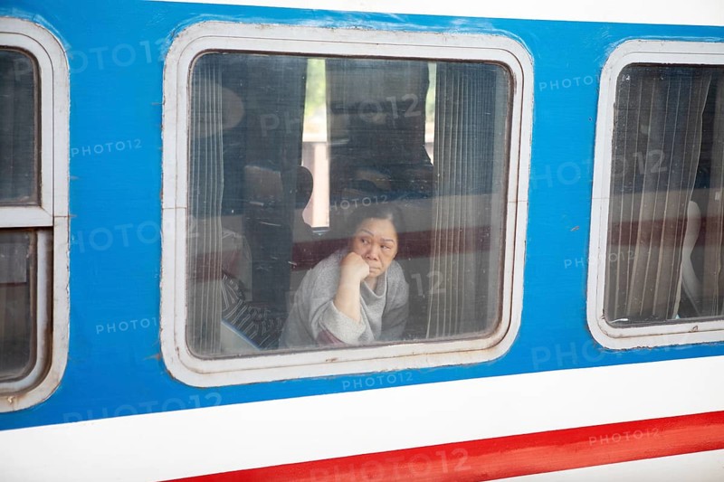 Vietnamese woman looking out of a train window, Hanoi, Vietnam, Asia